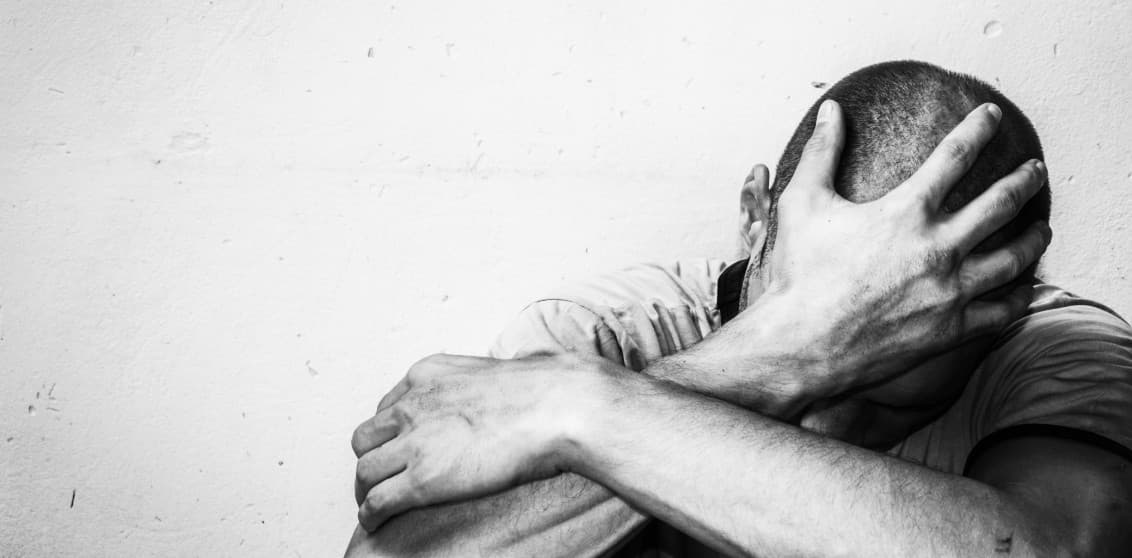 Black and white image of a man experiencing significant emotional distress, potentially related to the difficult subject matter of attempted first-degree murder. This image is intended to convey the emotional weight of such a crime. 
