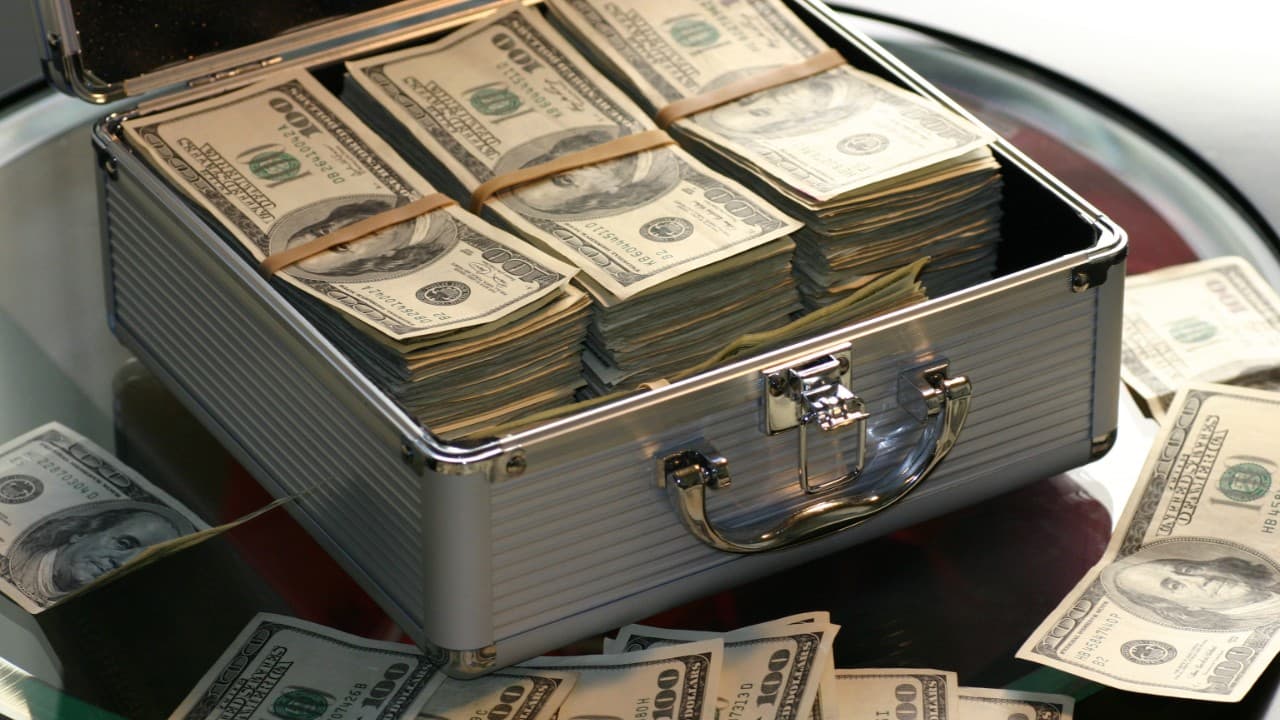 A briefcase filled with a large sum of money. This image illustrates the potential financial implications of a blackmail case.